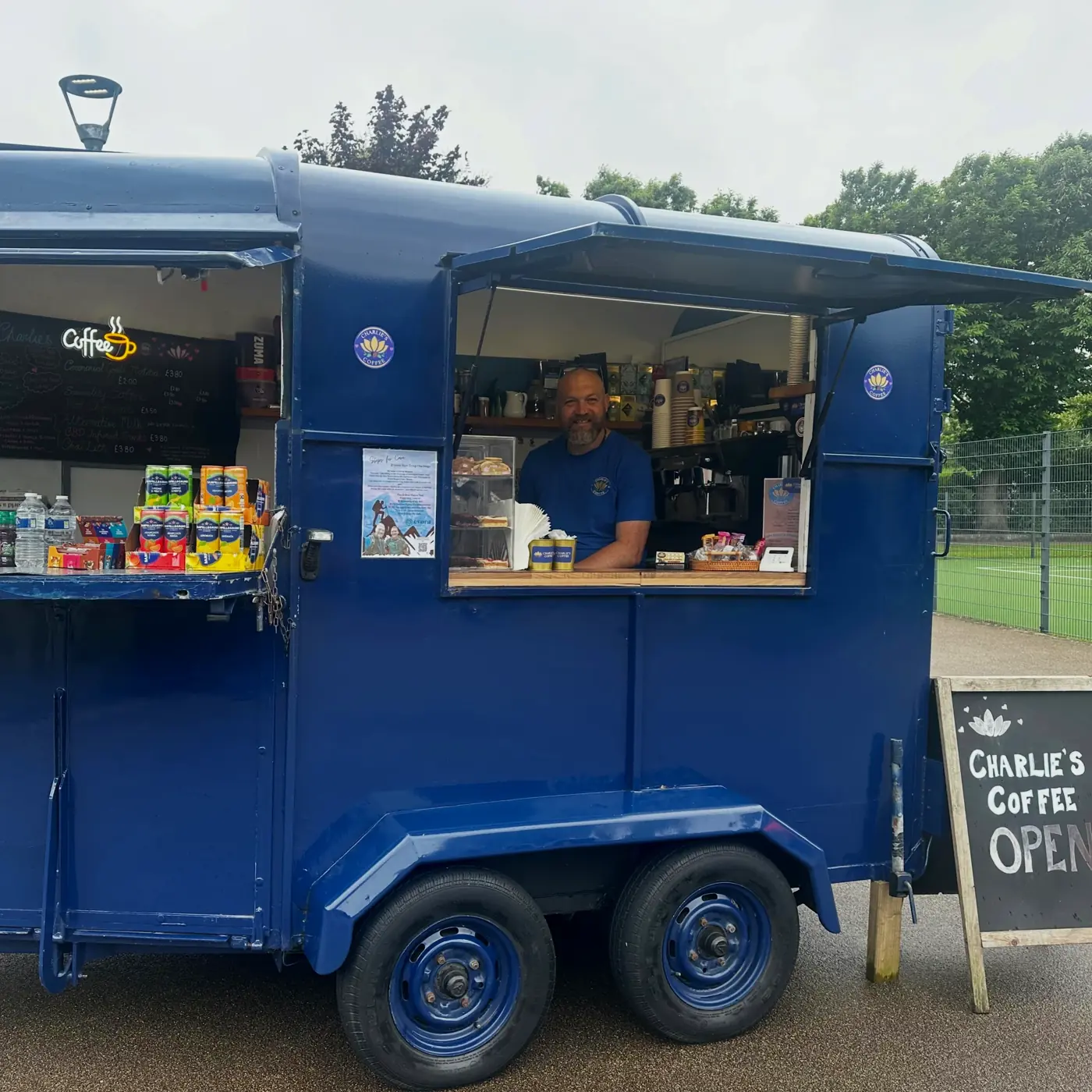The Charlie's Coffee royal-blue trailer serving customers at an event