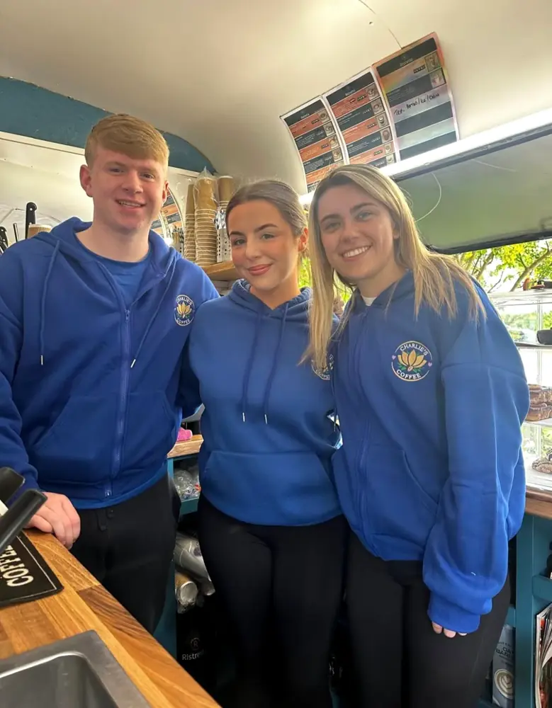 Charlie's Coffee team members smiling together behind the counter